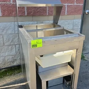 Stainless steel portable breading station. Features an overhead hood, open well top with divider, interior stainless shelf, and plastic tub. 24" x 30"