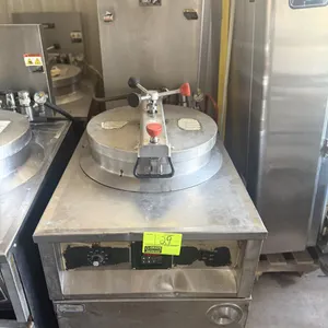 BKI FKM commercial pressure fryer. Stainless steel construction with round fry pot, locking lid assembly, digital timer control panel, and analog ther