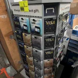 Laminate rotating merchandise display rack. Features a multi-sided revolving design with peg hooks and card display slots. 28"W x 54"H. Contents not i