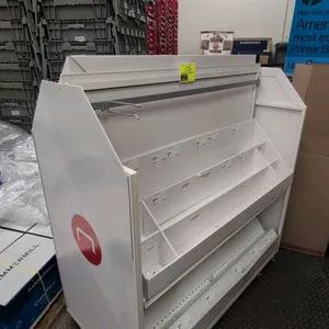 Double-sided mobile metal merchandise display rack. Features multi-tier divided shelves and organizer bins on both sides, top hanging display bar with