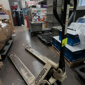 Crown manual pallet jack. Features manual hydraulic lift operation, loop handle with fingertip release control, and steel forks with entry rollers.