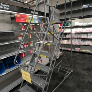 Rolling metal stock ladder. Features 7-step design with perforated steel slip-resistant treads, safety handrails, and upper platform guardrails. Dimen