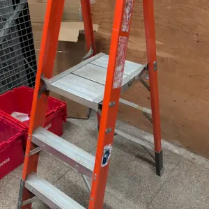 4' fiberglass platform ladder. Features orange non-conductive fiberglass rails, aluminum steps, folding work platform, top safety rail, and slip-resis