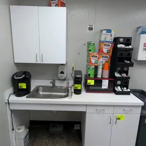 Laminate countertop unit with stainless steel sink and upper cabinet. Features white laminate construction, drop-in single-basin stainless steel sink 