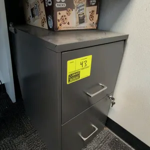 Metal 2-drawer filing cabinet. Features gray metal construction, silver-tone pull handles, and integrated lock with (2) keys included. 14"W x 24"H. Bo