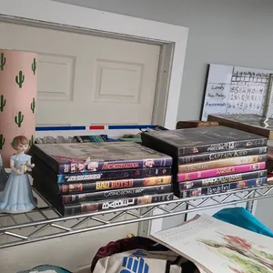 Lot Including Whole Top Shelf: DVDs, Ceramic Figurines, Decorative Items, and Miscellaneous Collecti