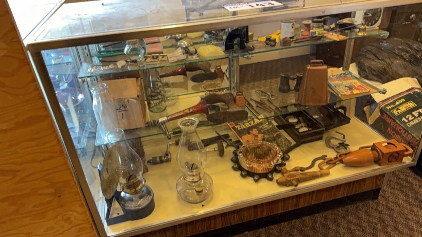 Glass Display Cabinet & Collectibles; Lanterns, Barrel Bungs, Pink Depression Glass, Sleigh Bells, Tarzan Comic Book