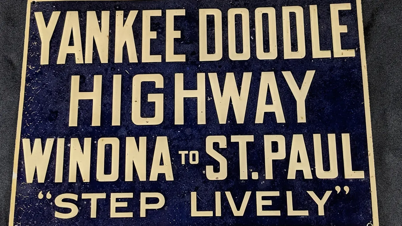EMBOSSED TIN SIGN YANKEE DOODLE HIGHWAY WINONA TO ST PAUL"STEP LIVELY"