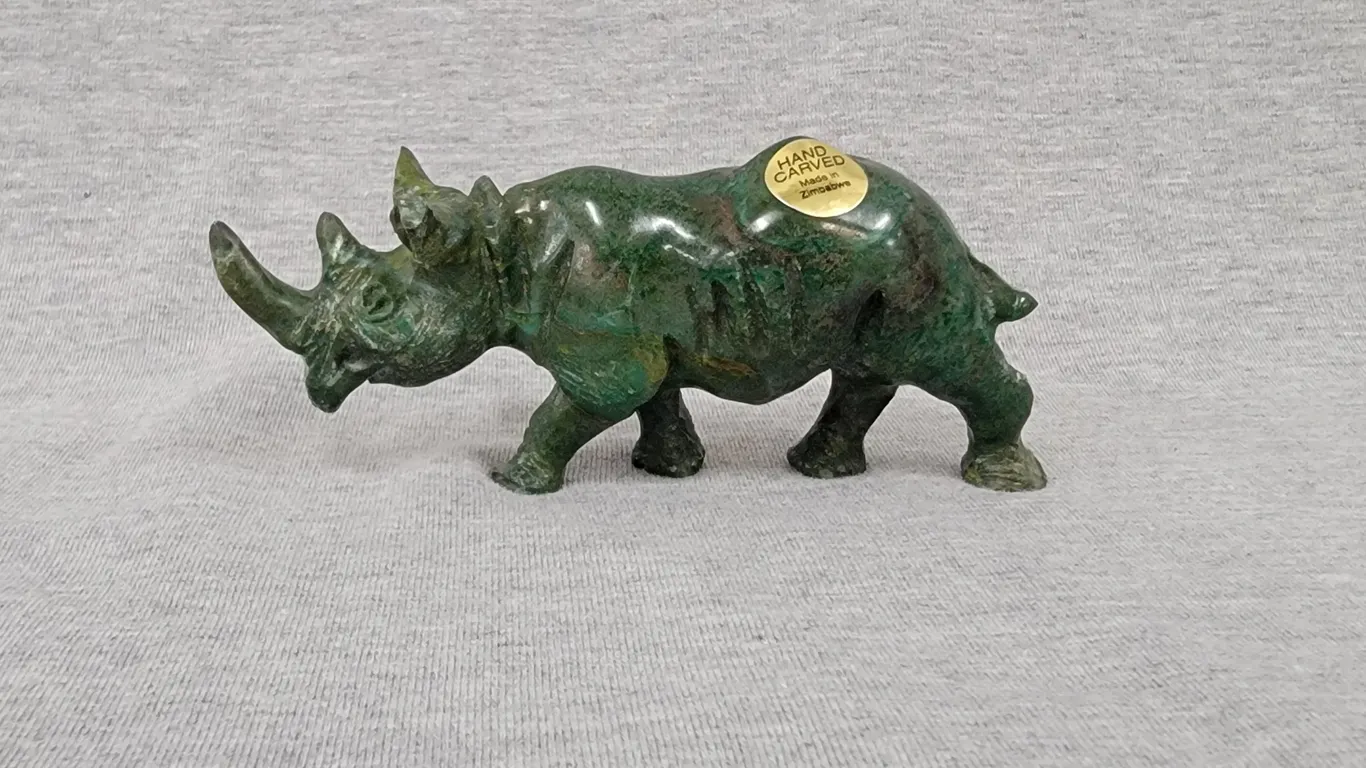 A Rhinoceros hand carved out of Verdite from the Shona Villages in Zimbabwe. Approximately 2" tall x 4.5" long. A