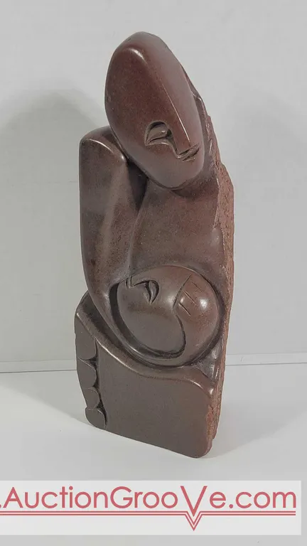 Mother with long flowing hair, cradling her child. Natural edges on sculpture. . 12" x 4.5 x 5. Est. $100 - $250 D5