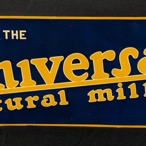 EMBOSSED TIN SIGN WE USE THE UNIVERSAL NATURAL MILKER
