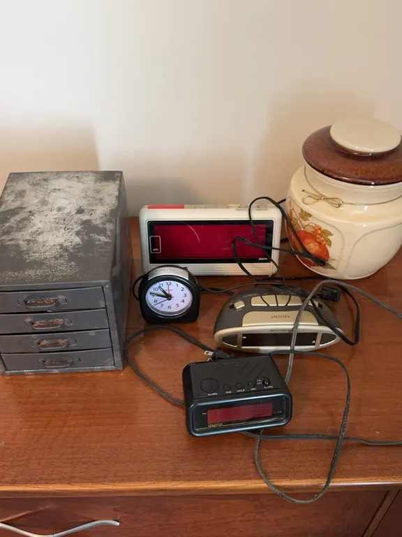 Metal Parts Storage Cabinet with Assorted Alarm Clocks and Canister
