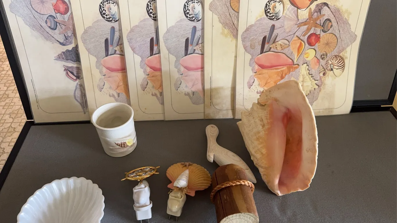 Collection of Coastal Decor Featuring Pink Conch Shell and Wooden Pelican