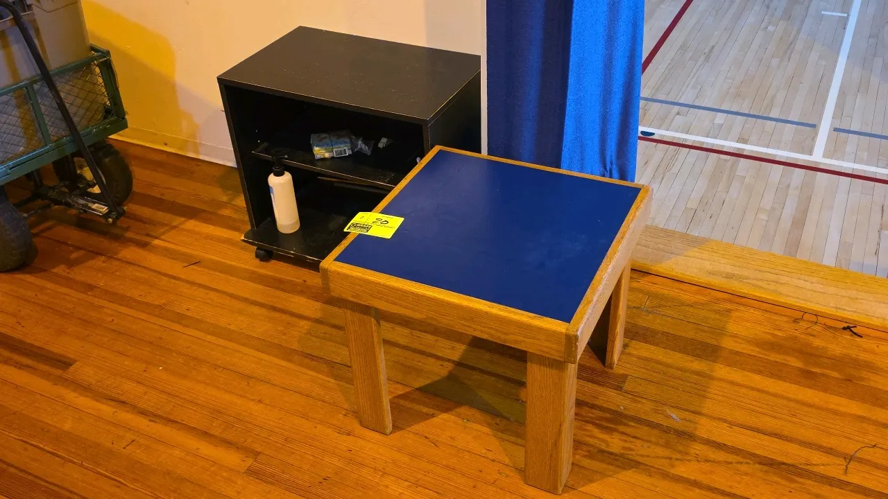 Table set. Includes one 18"H wood table with blue laminate top and one 21"H black laminate mobile side table with open shelf. Black table is mounted o