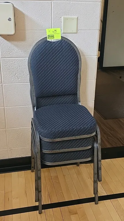 Upholstered cushioned metal base banquet chairs. Features blue patterned fabric upholstered seats and crown-style backrests. Hammered silver-tone meta