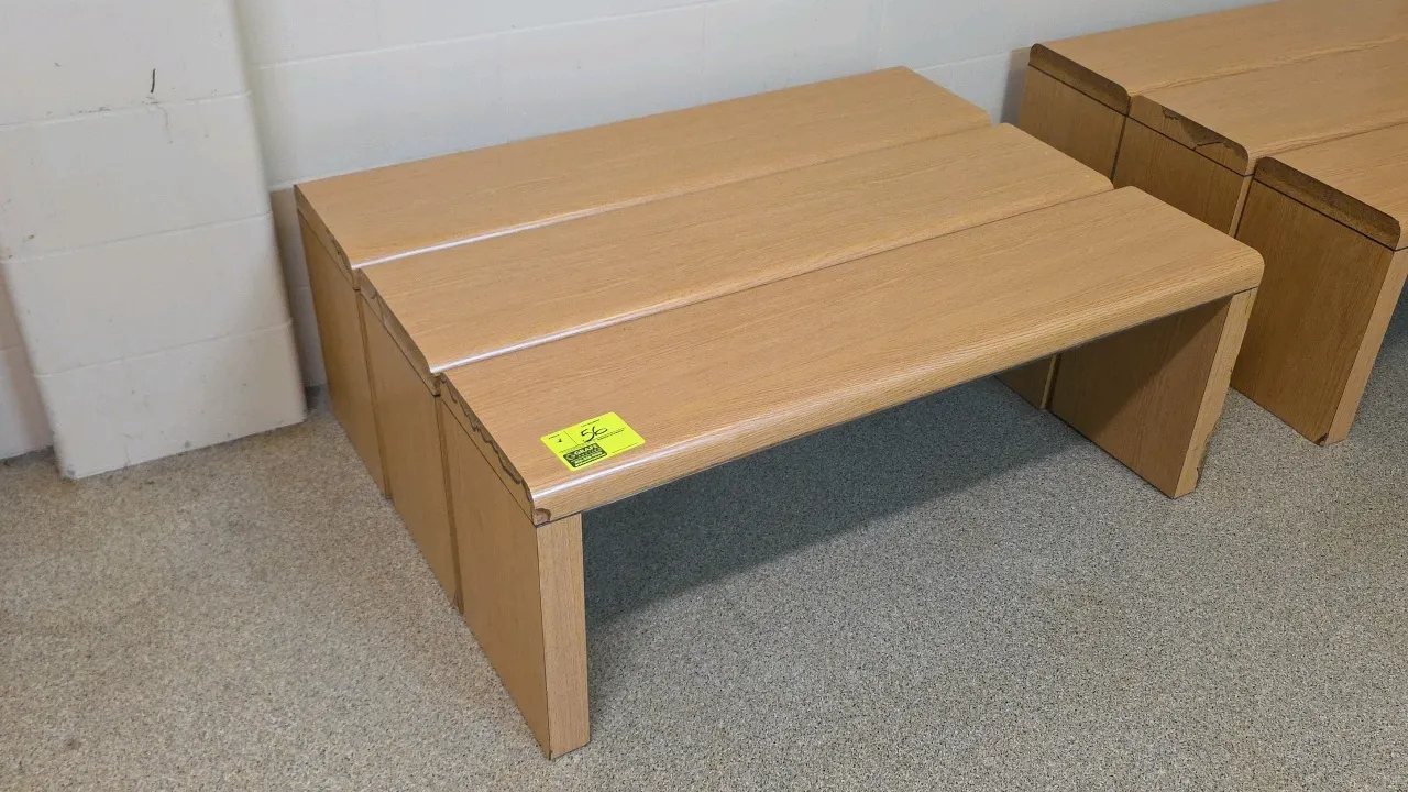 Laminate wood benches. Features a light woodgrain laminate finish, rounded bullnose edges, and panel leg bases. 48"L. Note: Units show chipped laminat