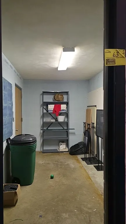 Room contents. Includes Contico 45-gallon portable trash can, 36"W x 85"H metal multi-tier storage rack, metal sign stands with frames, acrylic panels