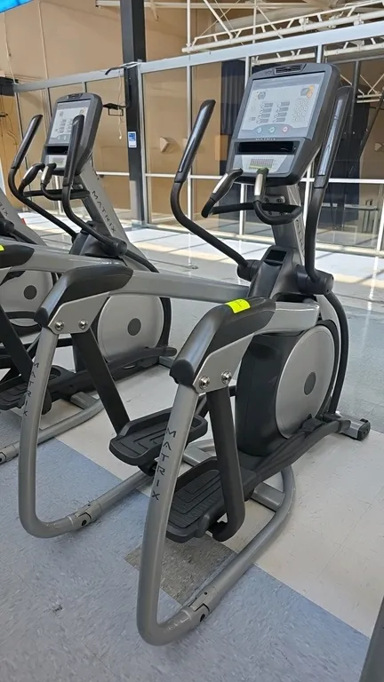 Matrix E-3x elliptical trainer. Features a digital console with multiple workout programs, integrated fan, contact heart rate grips, and handlebar lev