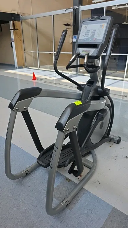 Matrix E-3X elliptical trainer. Features an LED console with integrated fan, preset workout programs, contact heart rate sensors, and accessory tray.