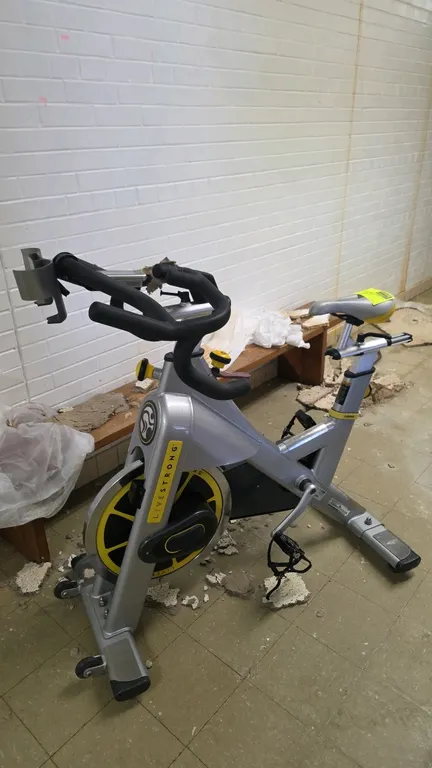 LiveStrong LS S-Series indoor cycling bike. Features adjustable seat and handlebars, manual resistance control knob with emergency brake, digital disp