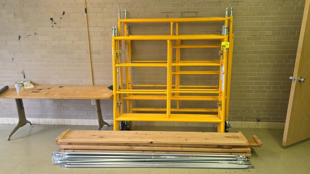 Bil-Jax scaffolding. Features 8 upright frames, crossbraces, and 4 wooden walkboards. Dimensions: 5' x 5' frames. Mounted on 4 casters.