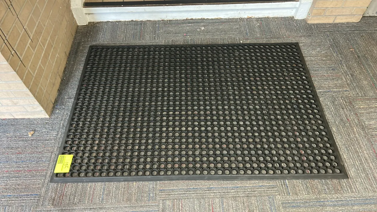 Poly floor mat. Features a black rubberized construction with a molded ring drainage pattern designed for scraping and anti-slip safety. 5'L.