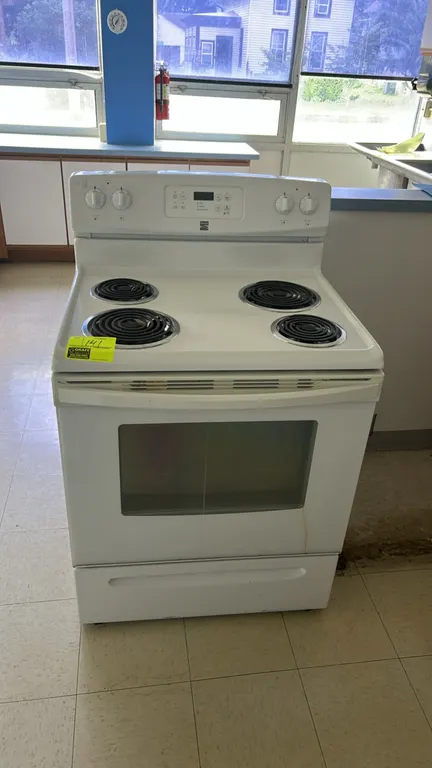 Kenmore electric range. Features four coil burners, digital display, and oven with window. Includes two interior wire racks and bottom storage drawer.