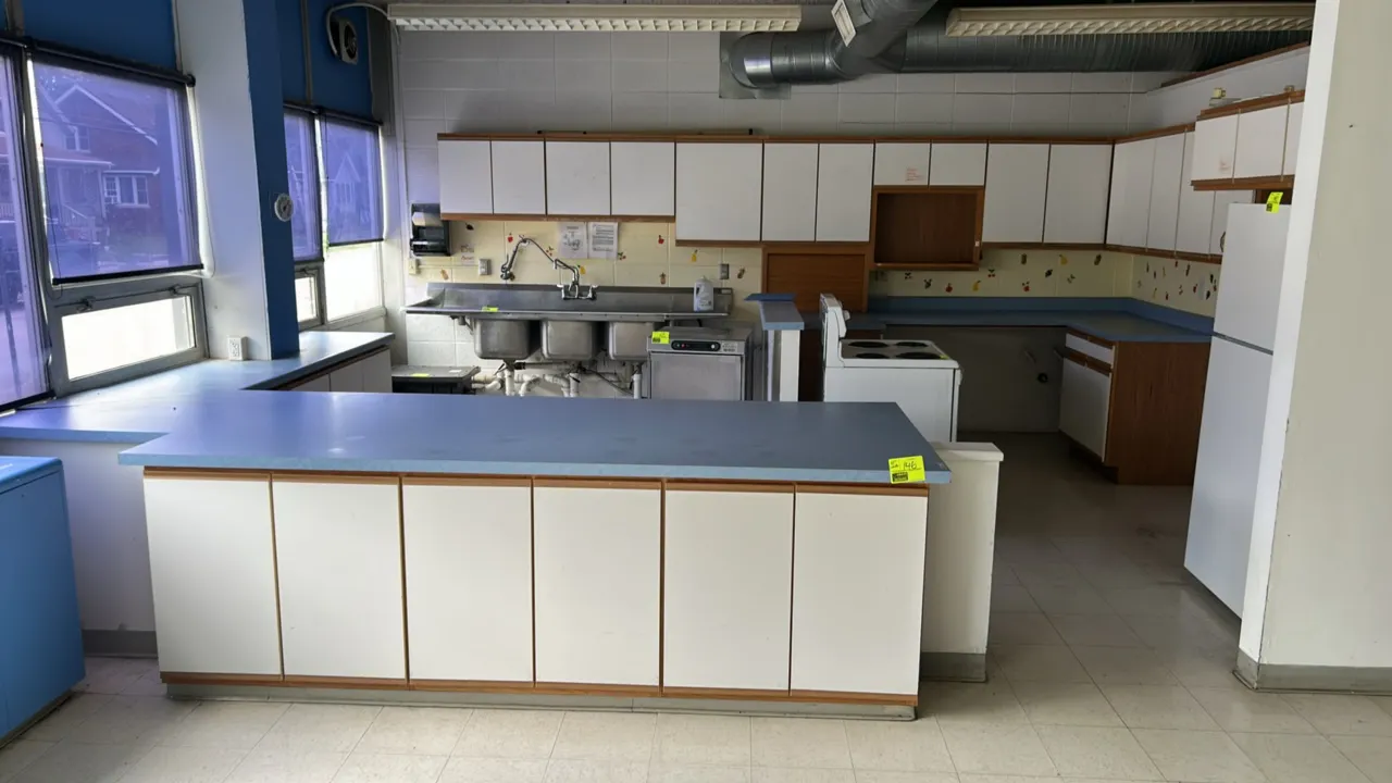 Laminate kitchen cabinetry and countertops. Includes wall-mounted upper cabinets and base cabinets with a peninsula counter. Features white laminate d