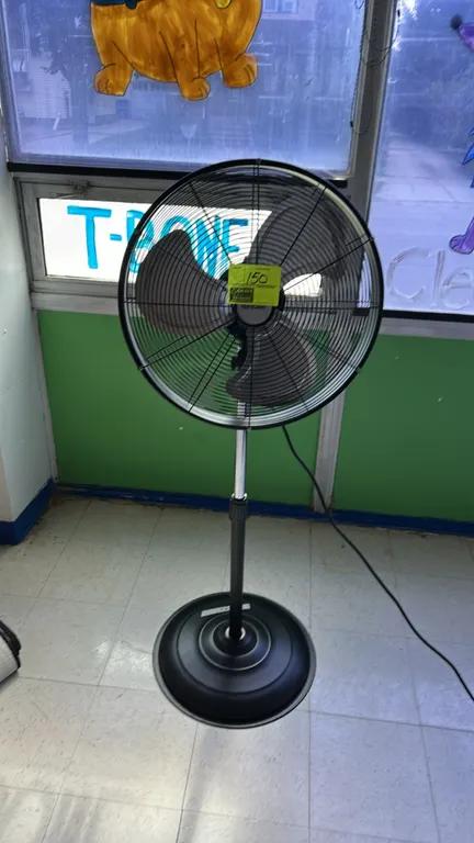 Hurricane standing pedestal fan. Features a 3-blade metal fan assembly enclosed in a wire safety guard. Equipped with an adjustable height support pol
