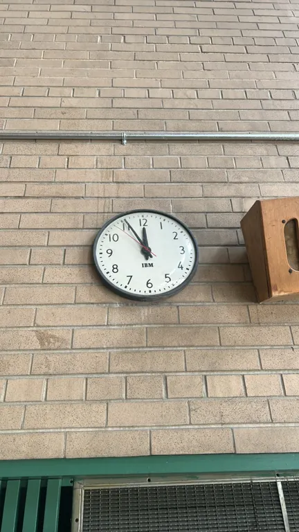Assorted IBM wall clocks. Includes one double-sided bracket-mounted corridor clock and one single-sided round wall clock. Features white dials with bl
