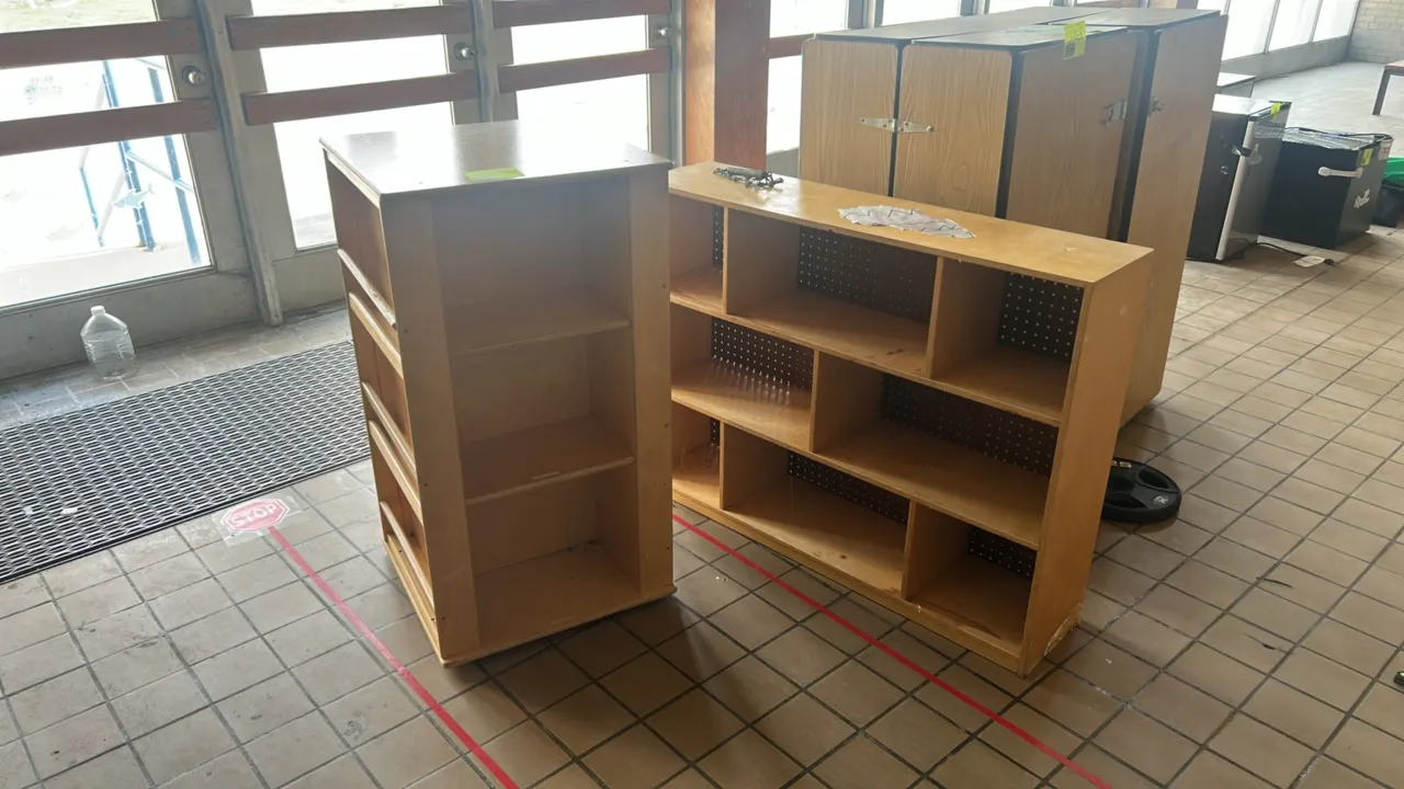 Laminate storage shelves. Includes one tall double-sided bookcase featuring three open shelves on one side and book display rails on the reverse, and