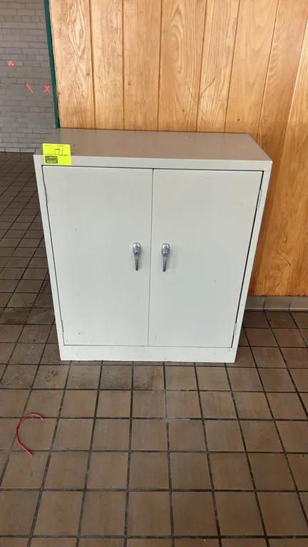Metal 2-door storage cabinet. Features dual locking-style handles and two interior shelves providing three levels of storage. Beige finish. Note: Keys