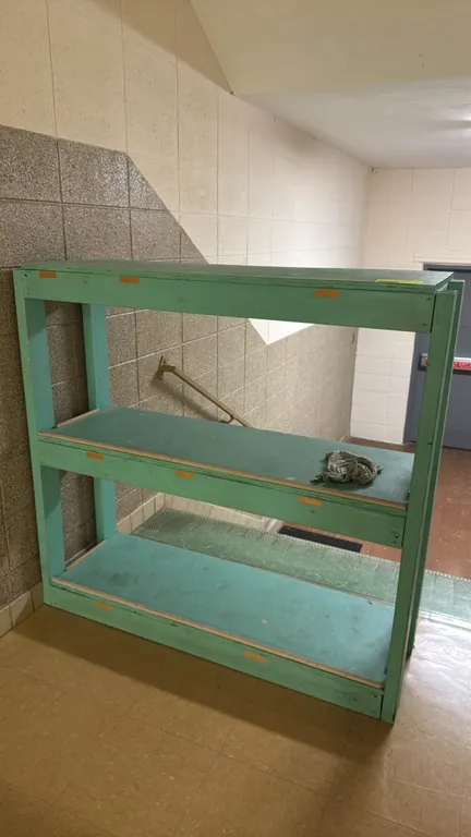 Wooden 3-tier shelving rack. Features green-painted wood construction with three solid shelf levels. 4'L. Ground-standing base.
