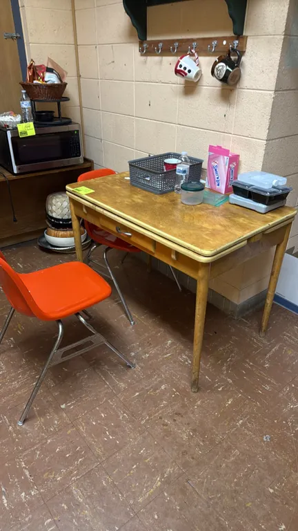 Wood table and chair set. Includes one vintage wood table with a drawer and pull-out extension leaf, two orange molded plastic chairs on metal legs, a