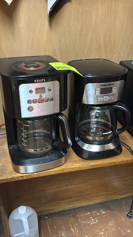 Coffee brewers. Includes (1) Krups programmable coffee maker and (1) Black & Decker programmable coffee maker. Both units feature black and stainless