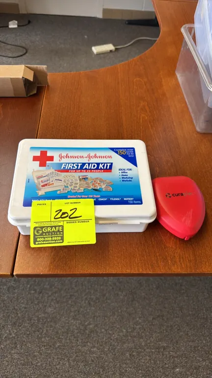 Johnson & Johnson first aid kit. Features a white plastic case containing various first aid supplies including bandages, gauze, and an Insta-Kool inst