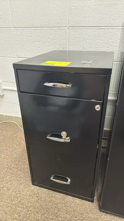 Metal 3-drawer file cabinet. Features a black finish, one shallow utility drawer, and two deep filing drawers. Equipped with chrome-finished pull hand