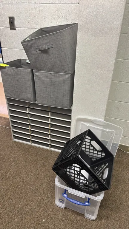 Laminate mail sorter. Features white laminate construction with 24 sorting slots. Includes three gray fabric storage cubes, one clear plastic lidded s