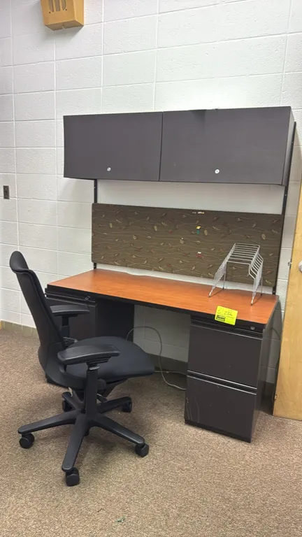 Metal desk with wood-laminate top, overhead hutch, and task chair. Desk features a double-pedestal metal base with four drawers total. Hutch includes