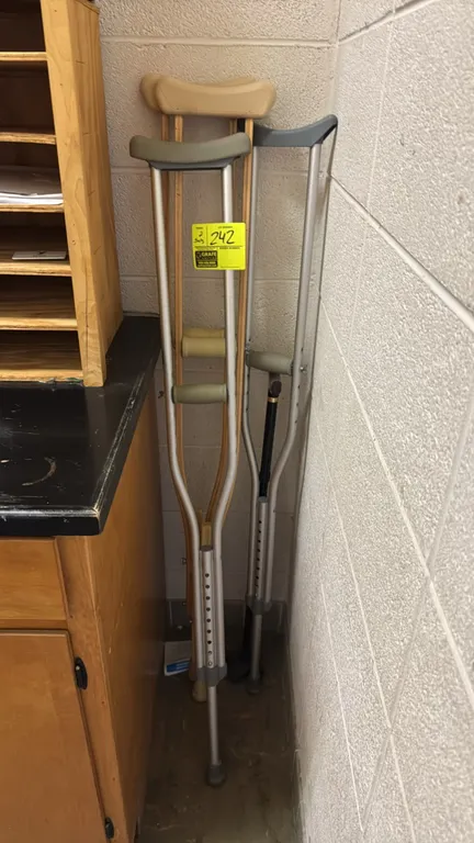 Wood and aluminum crutches. Includes one pair of wooden crutches and one pair of adjustable aluminum crutches. A black walking cane is also included.