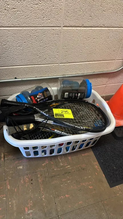 Racquetball equipment lot. Includes various racquetball racquets, two jars of Penn Ultra-Blue racquetballs, and an athletic glove. Featured brands inc