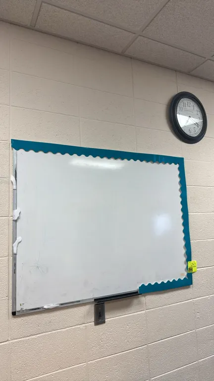 Dry erase board with wall clock. Includes a whiteboard with a bottom accessory tray and a La Crosse Clock Co. analog wall clock with a black frame. Di