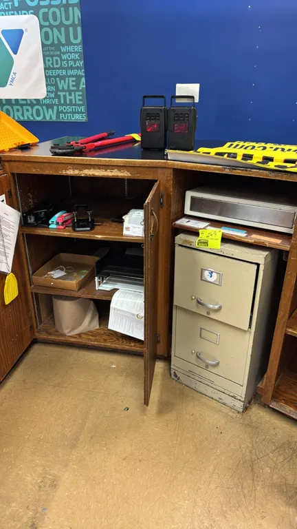 Metal 2-drawer file cabinet with assorted office supplies. Features a tan metal vertical file cabinet. Includes office supplies such as manual stapler
