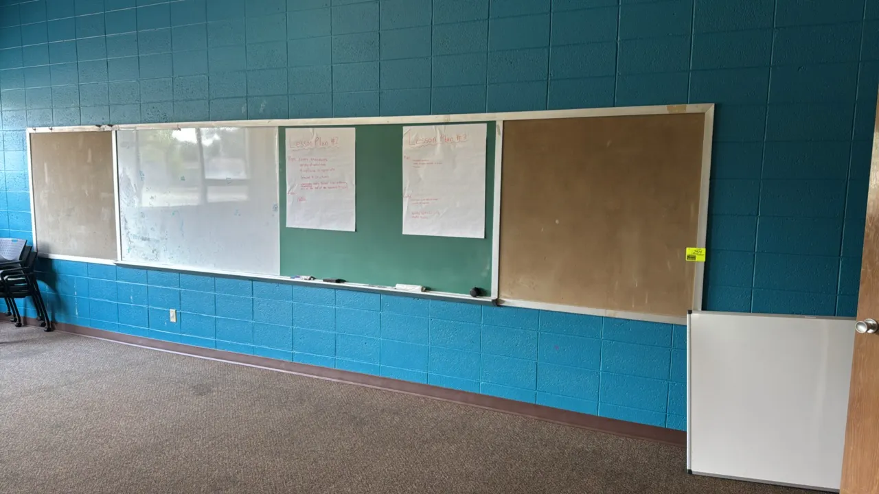 Combination wall-mounted board featuring a green chalkboard, a dry erase whiteboard, and two cork bulletin board sections. Constructed with an aluminu