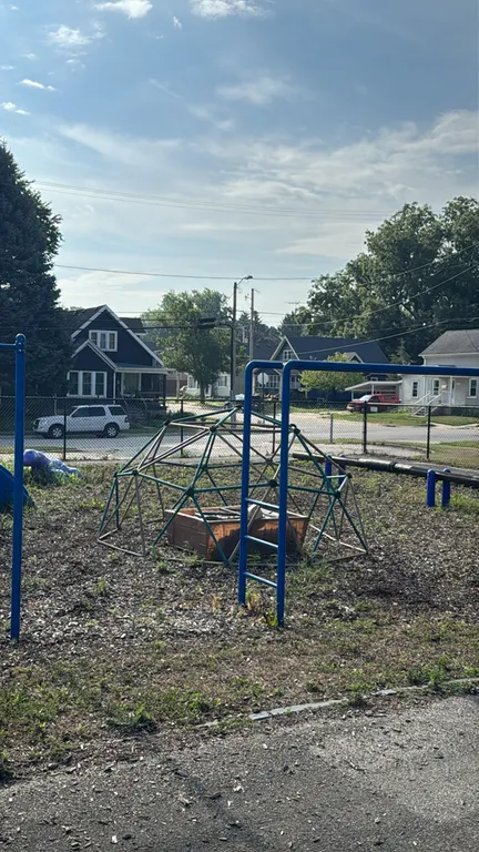 Metal geodesic climbing dome structure. Features green and tan powder-coated metal bars with interconnected hub construction in an igloo shape. Note: