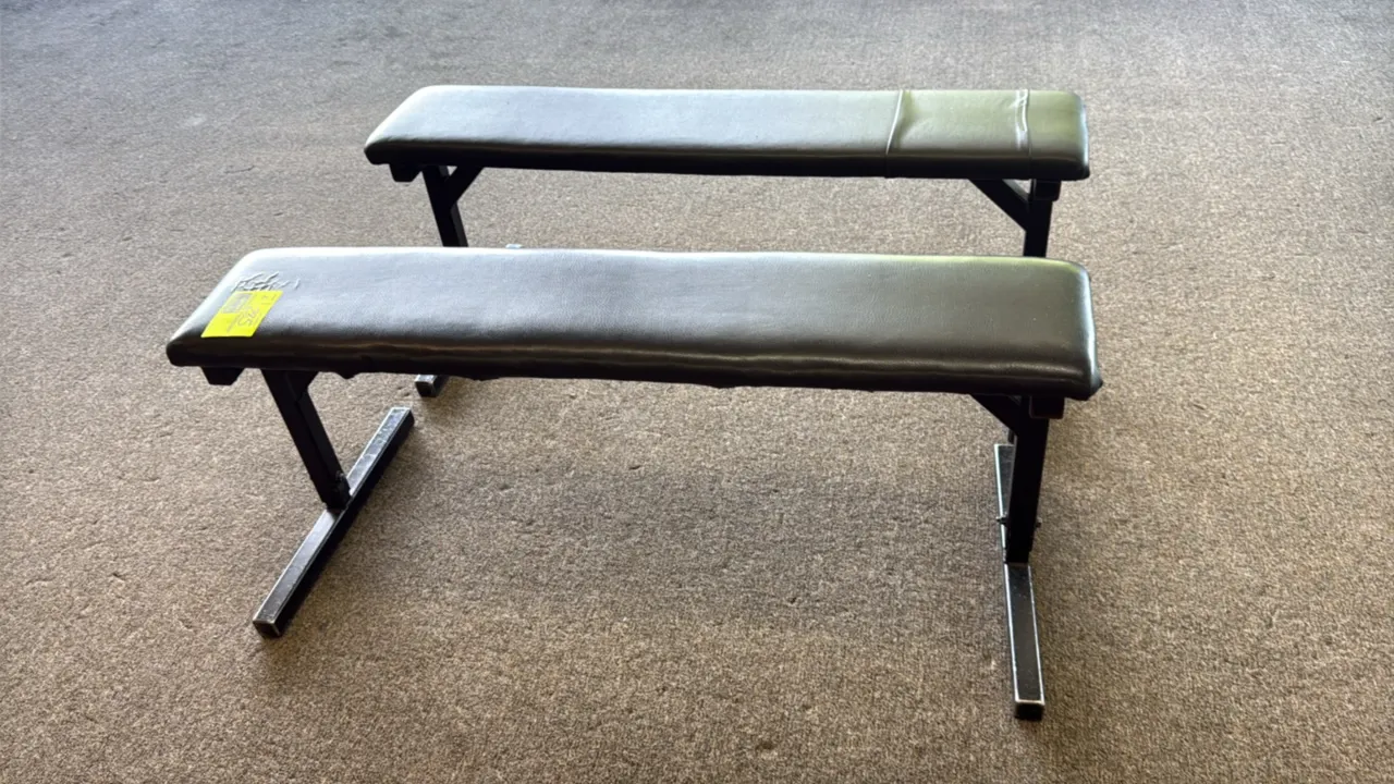 Workout padded benches. Features black vinyl upholstered padding and black steel frames. Flat design with T-shaped base stabilizers. 4'L. Note: One be