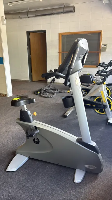 Matrix upright exercise bicycle. Features a digital console with an integrated cooling fan, USB port, numeric keypad, and multiple pre-programmed work