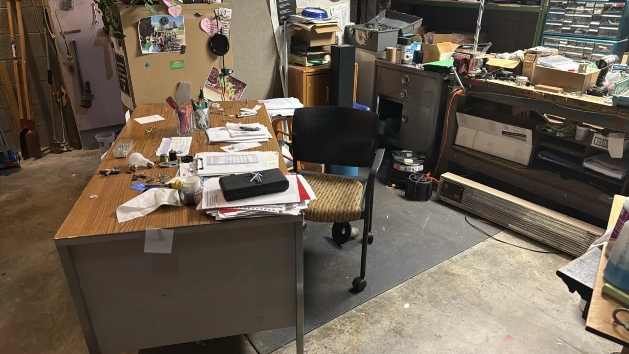 Workshop lot including a double-pedestal office desk, wooden workbenches, office chair, and metal rolling cabinet. Includes contents: a 6" bench grind