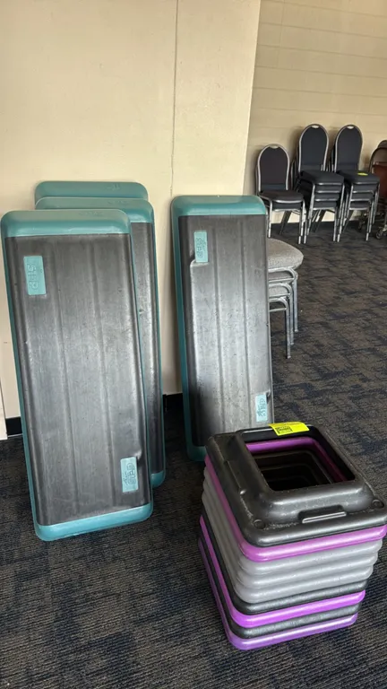 The Step aerobic step platforms with risers. Features (4) teal and black poly step platforms with non-slip textured top surfaces. Includes (8) stackab