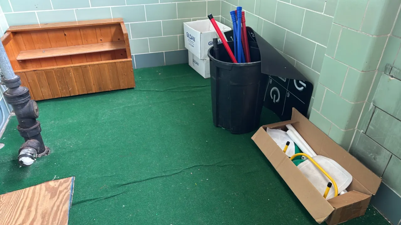 Physical education equipment package. Includes a stained wood storage bench with center shelf, a black plastic storage bin, red and blue poly hockey s